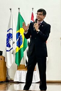 Diretor presidente da Seicho No Ie José Adalton em pé no palco da academia de Ibiúna, proferindo uma palestra